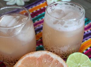 Close-up of two skinny paloma margarita drinks placed upon a striped cloth.