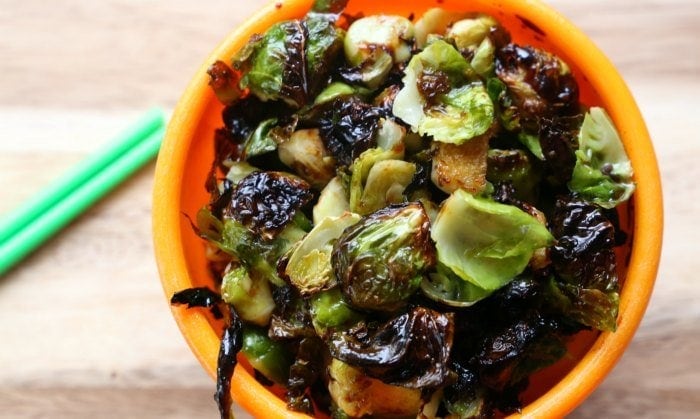 Crispy sugar free Asian Brussels sprouts in an orange bowl.