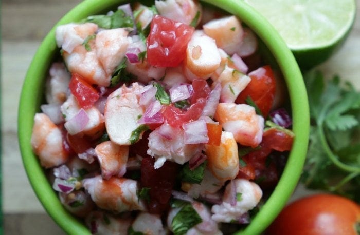 Shrimp ceviche piled in a green bowl.