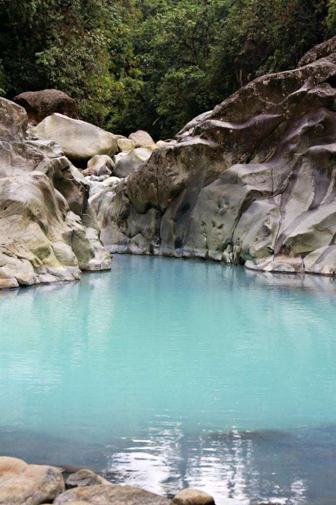 Aquamarine pool surrounded by boulders, Bajos del Toro Costa Rica.
