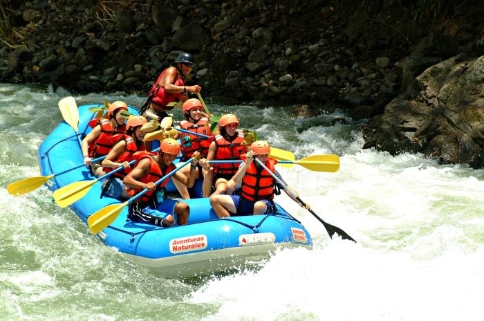Group of white water rafters paddling through the rapids of Pacuare River Costa Rica.