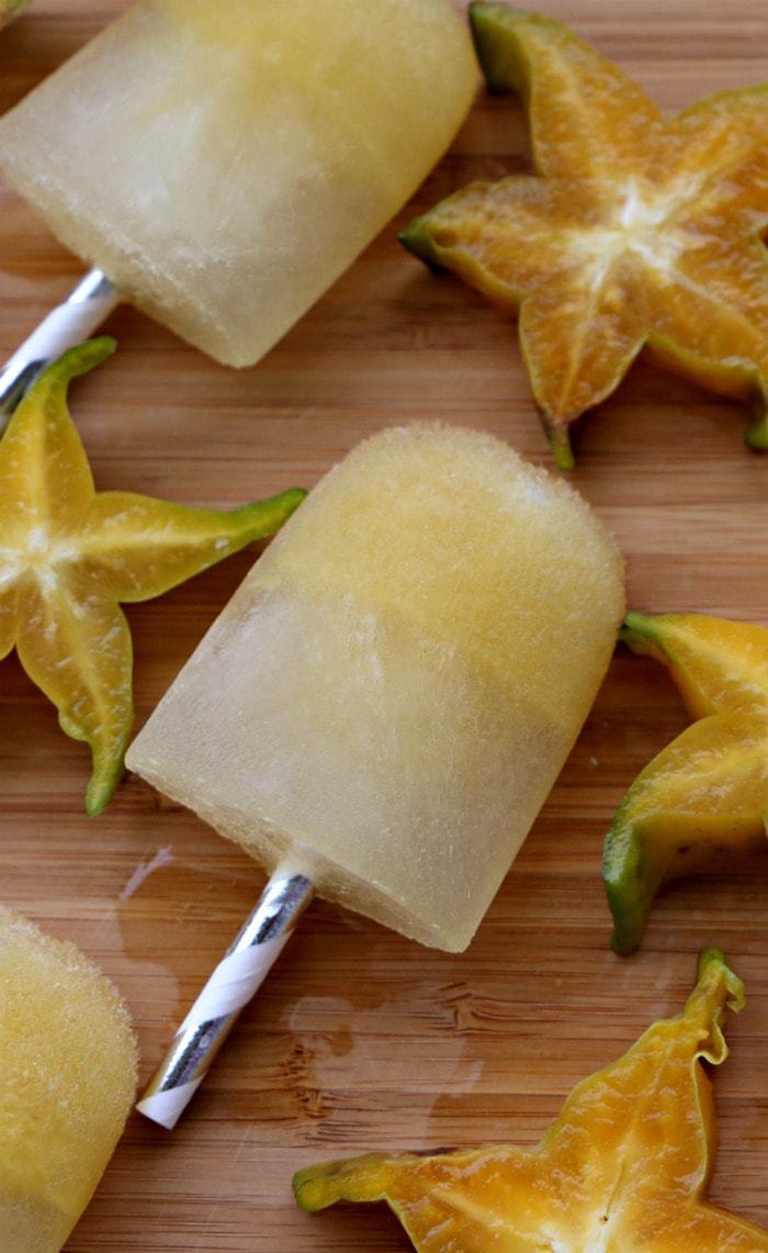 Array of popsicles on a cutting board with starfruit next to them