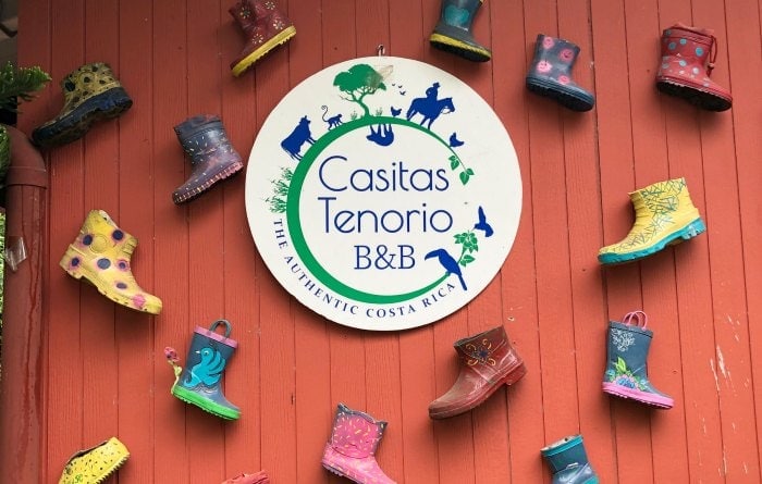 Entrance to Casitas Tenorio Costa rica bed and breakfast with logo and rubber boot wall