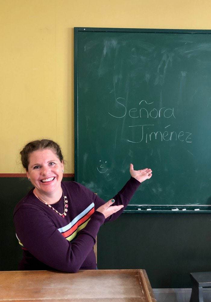 Spanish teacher in classroom in front of blackboard