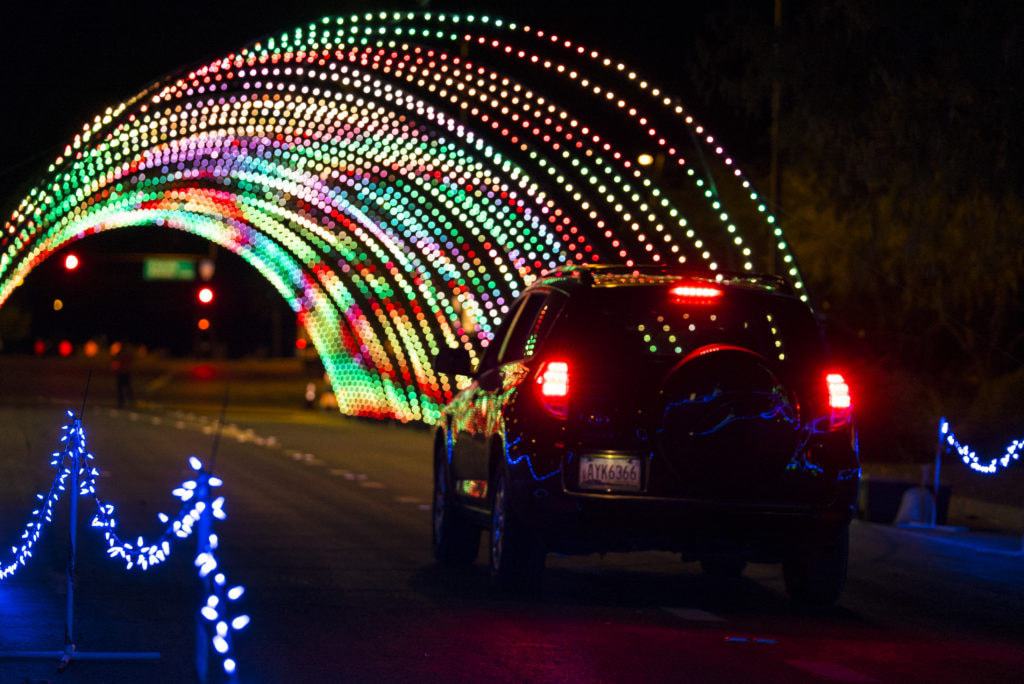 Car driving through tunnel of lights at Christmas in Color.