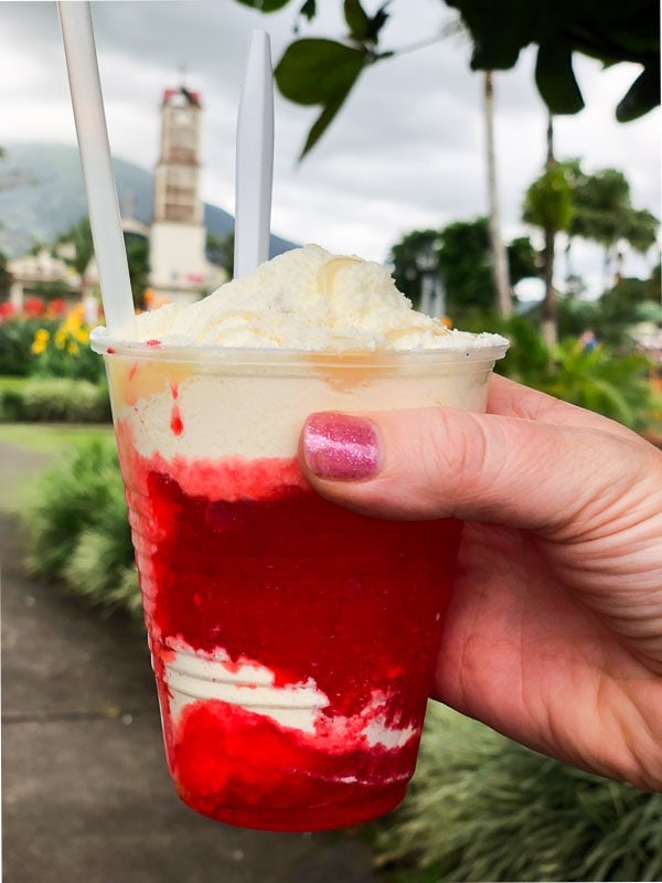 Costa Rican snow cone with red syrup in park in La Fortuna.