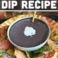 The black bean dip in a serving bowl that is placed on top of a plate.
