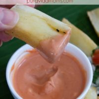 Costa Rican fry being dipped in sauce.