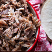 The shredded pork in a red serving dish.