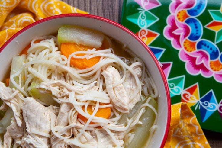 Bowl of Costa Rican chop suey next to a painted disc.