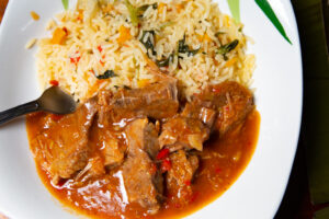 Platter consisting of meat in thick brown sauce and rice.