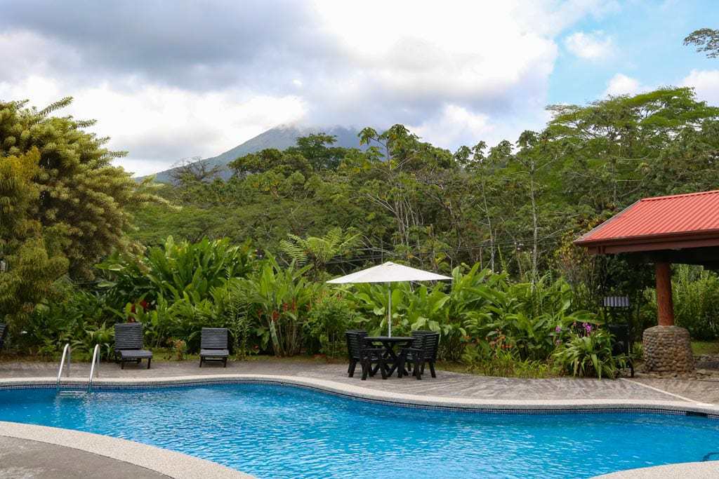 costa rican hot springs pool and lounge area with volcano in background.