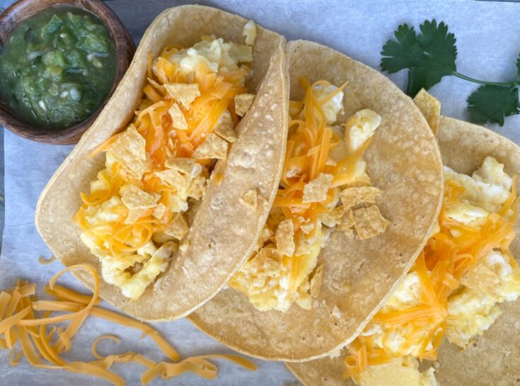 three homemade migas torchy's tacos with side of green salsa