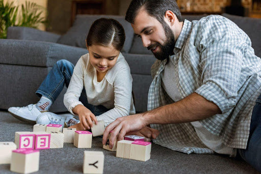 man and child playing blocks on the floor